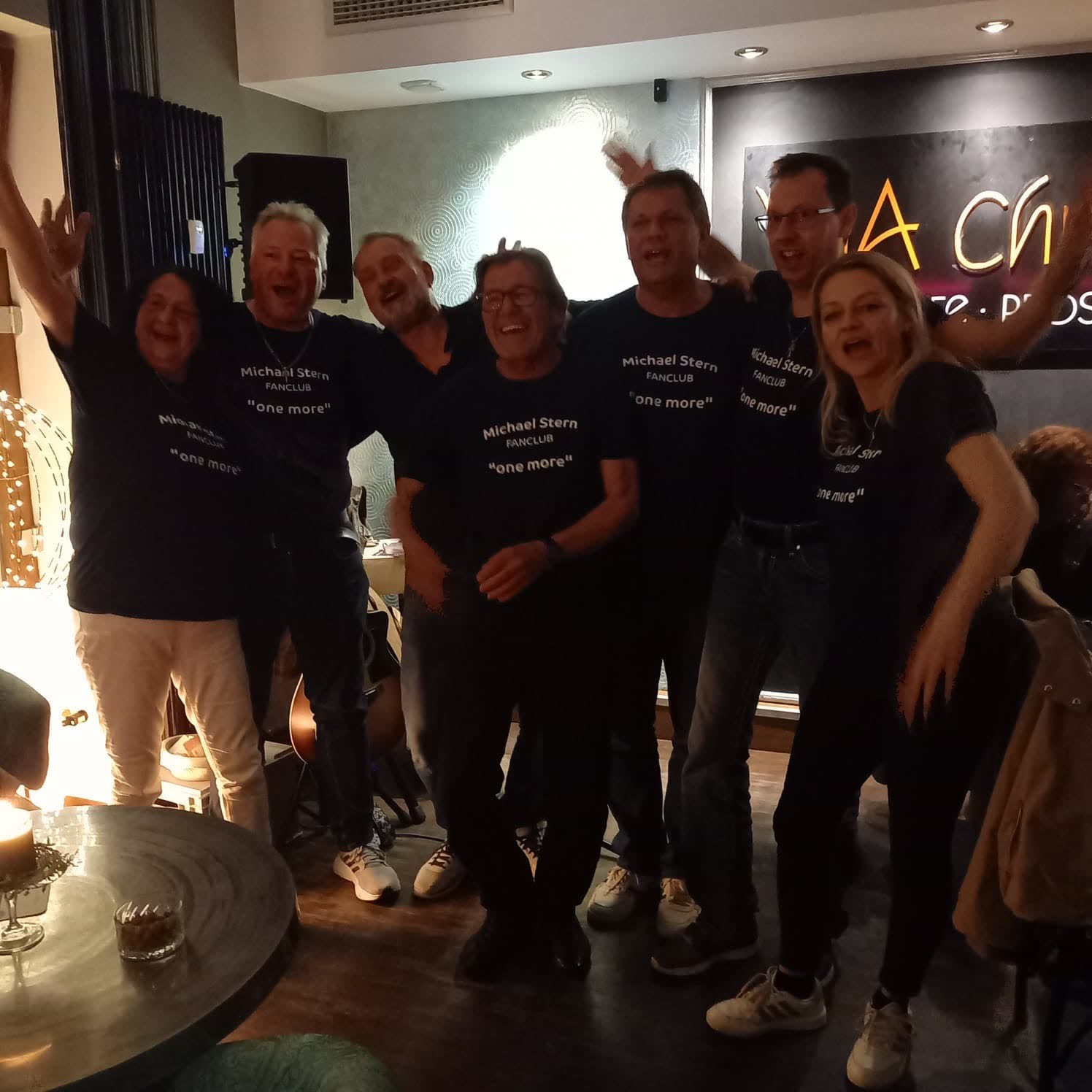 Fans in schwarzen T-Shirts mit der Aufschrift „Michael Stern Fanclub – one more“ jubeln mit erhobenen Armen